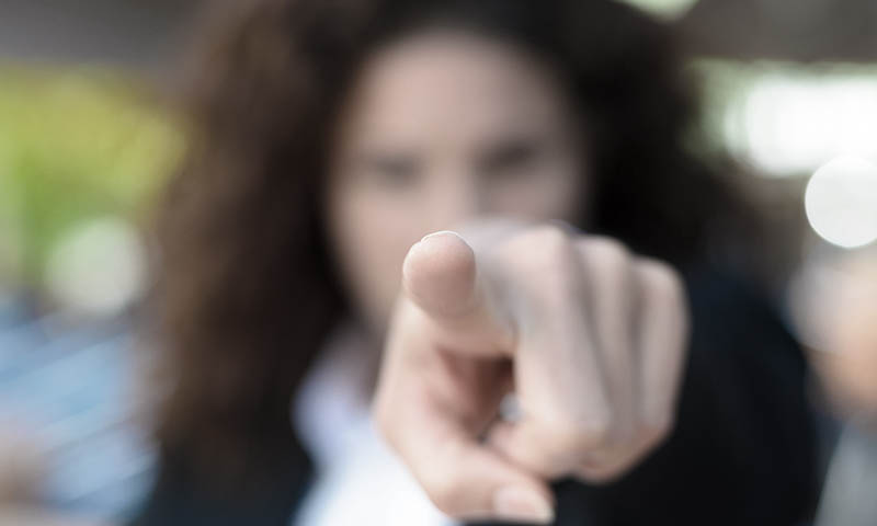 Frau die mit Zeigefinger auf einen Sexualstraftäter zeigt