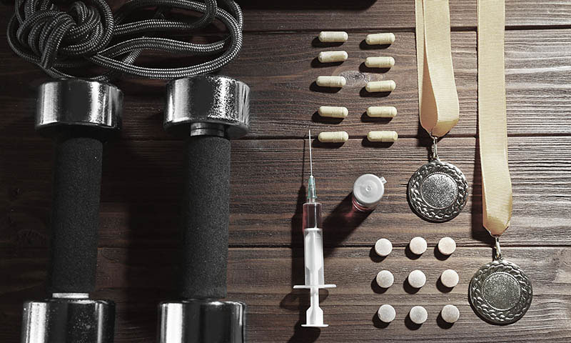 Syringe with dumbbells and pills, top view. Doping in sport conc